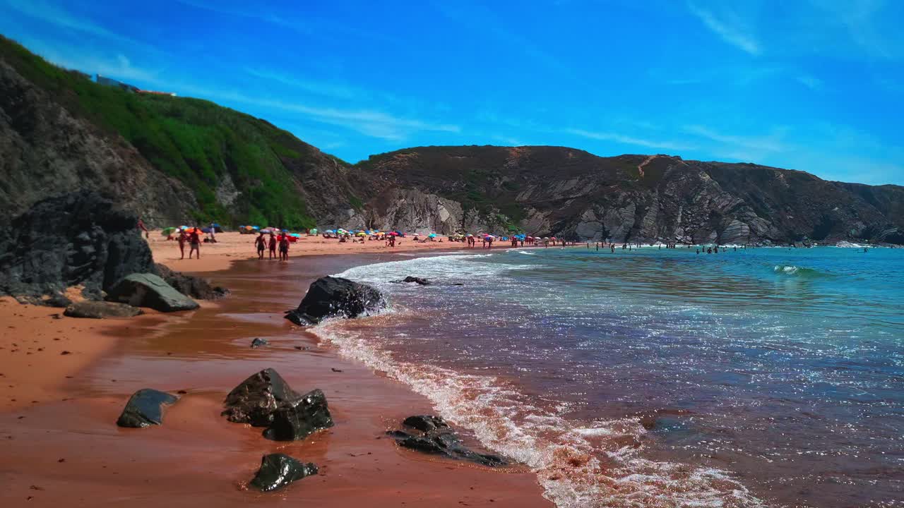 People enjoying the sand and sun at Praia da Am&aacute;lia Beach, Portugal