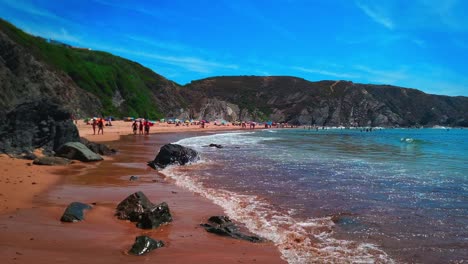 people enjoying the sand and sun at praia da amália beach, portugal