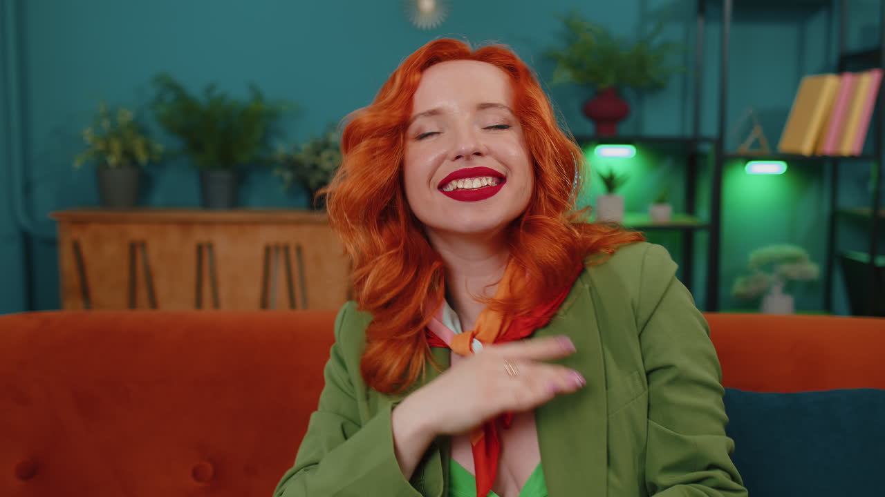 무선 헤드폰을 입은 행복한 젊은 은 머리 소녀가 춤추고 노래하고 집 방에서 좋아하는 노래를 듣고 있습니다.