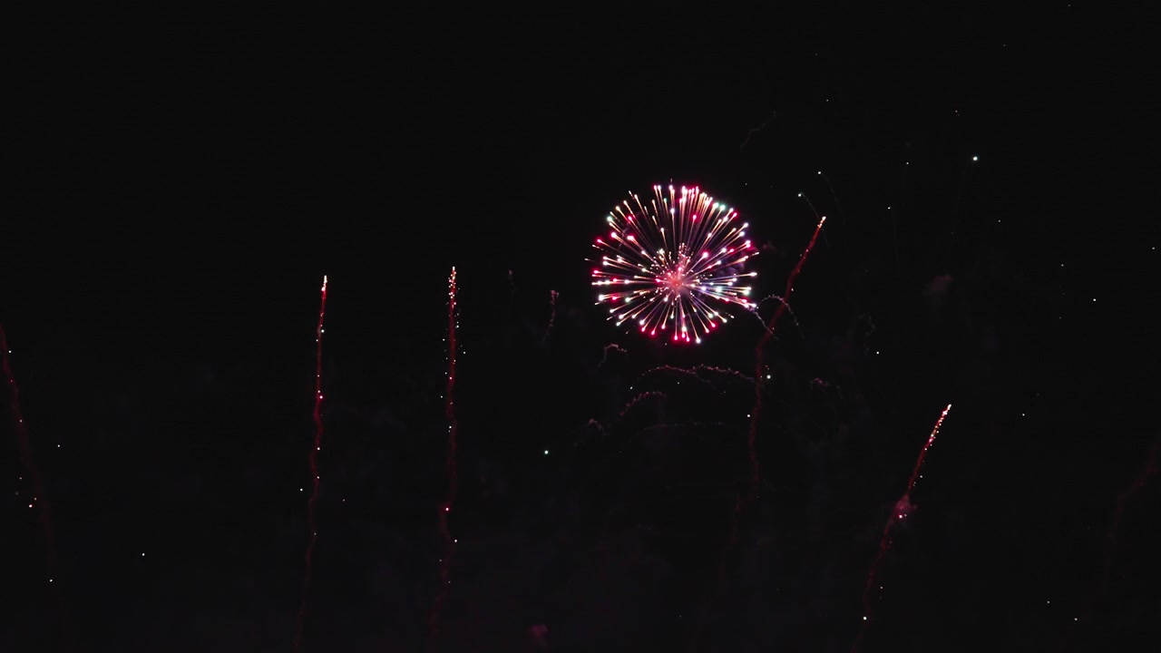 Dazzling fireworks bursts creating glowing patterns in night sky