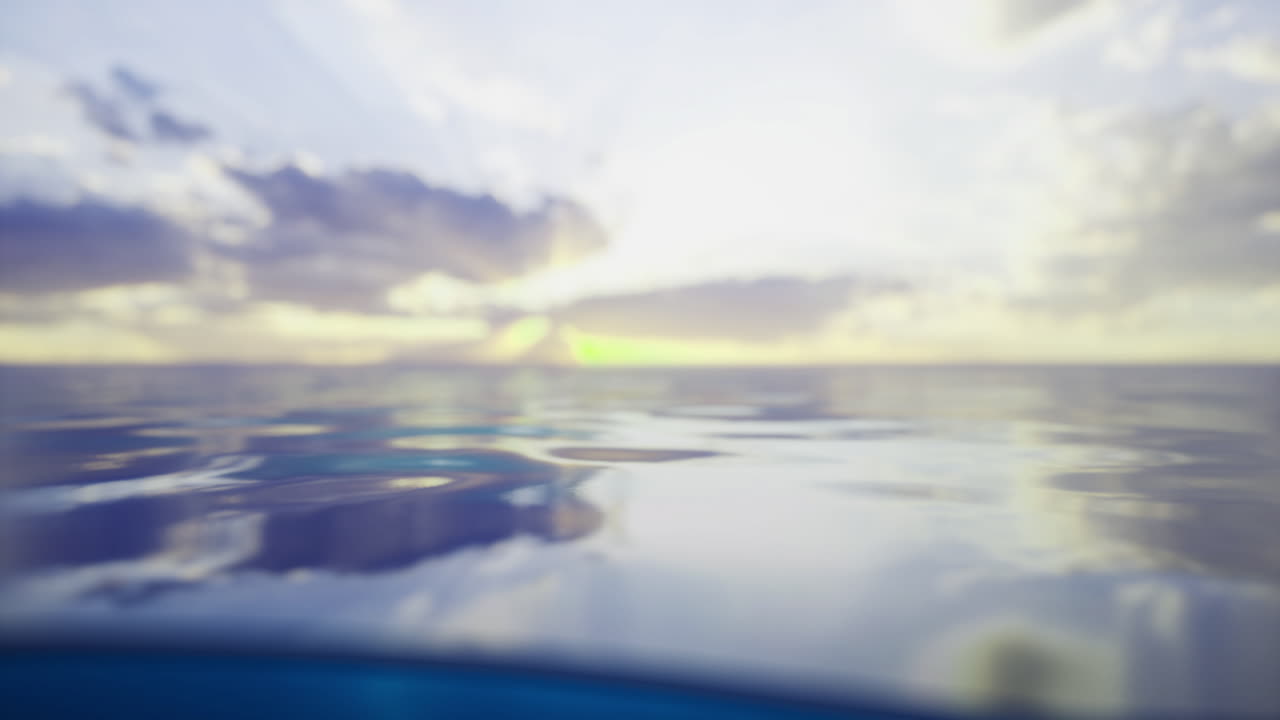 Calm ocean waters reflect the colorful sky at sunset near the horizon
