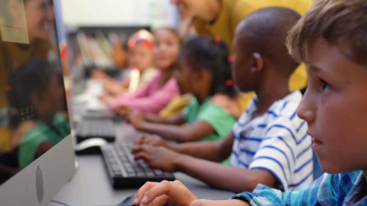 Side view of mixed-race schoolkids studying on computer in the classroom 4k