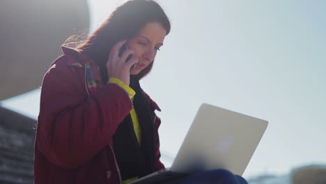 mujer madura con una computadora portátil de rodillas trabajando de forma remota