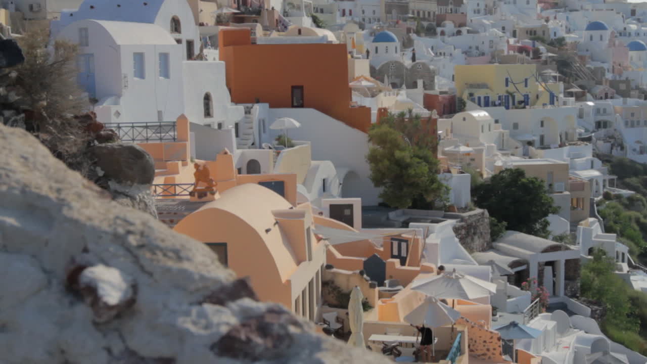 vista de casas de vacaciones y villas entre iglesias de cúpula azul y campanas de iglesia en oia santorini