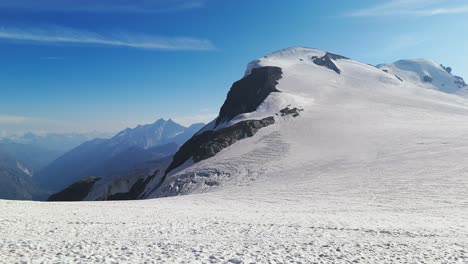 aerial drone shot pushing toward a massive snow-covered mountain in the swiss alps, zermatt