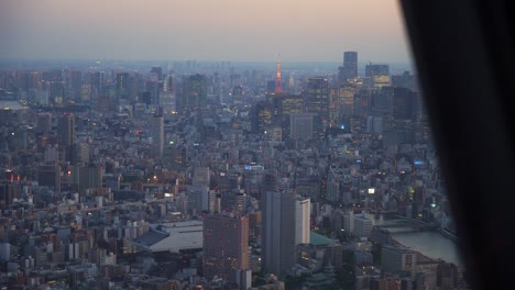 views of tokyo tower and vast congested cityscape from tower skytree at dusk.