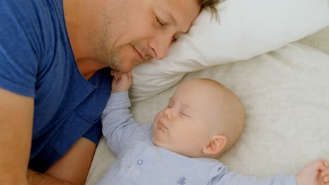 Father-and-baby-boy-sleeping-in-bedroom-4k