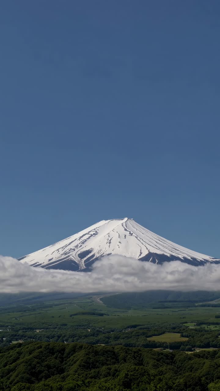 A stunning video still of a snow-capped mountain peak, captured from a low angle, showcasing a clear