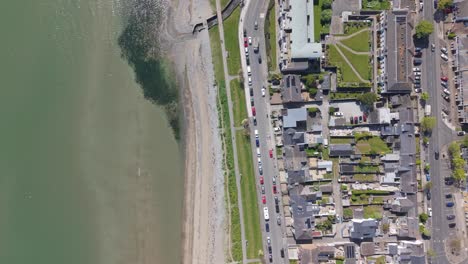 top down aerial view of seaside town, parallel road and beach of skerries coastline