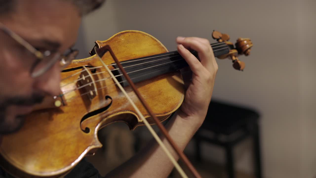 Adult bearded luthier playing hand crafted violin