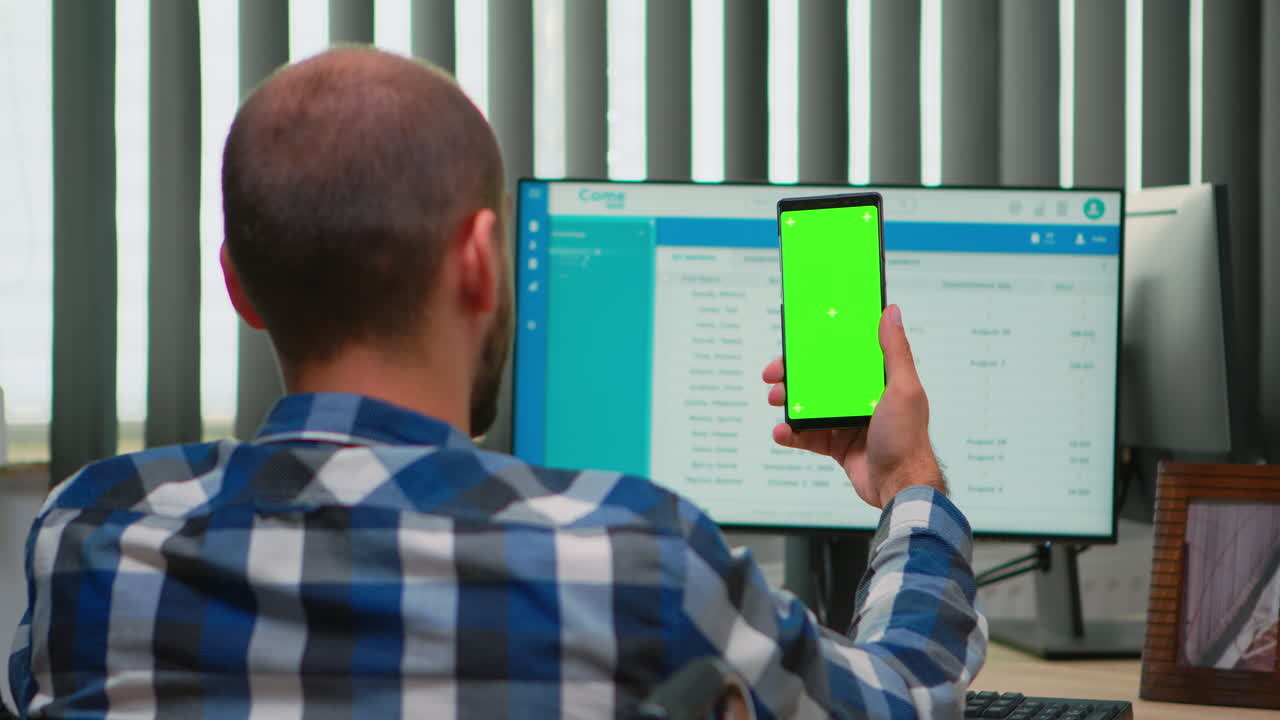 hombre de negocios en silla de ruedas usando un teléfono inteligente con pantalla verde