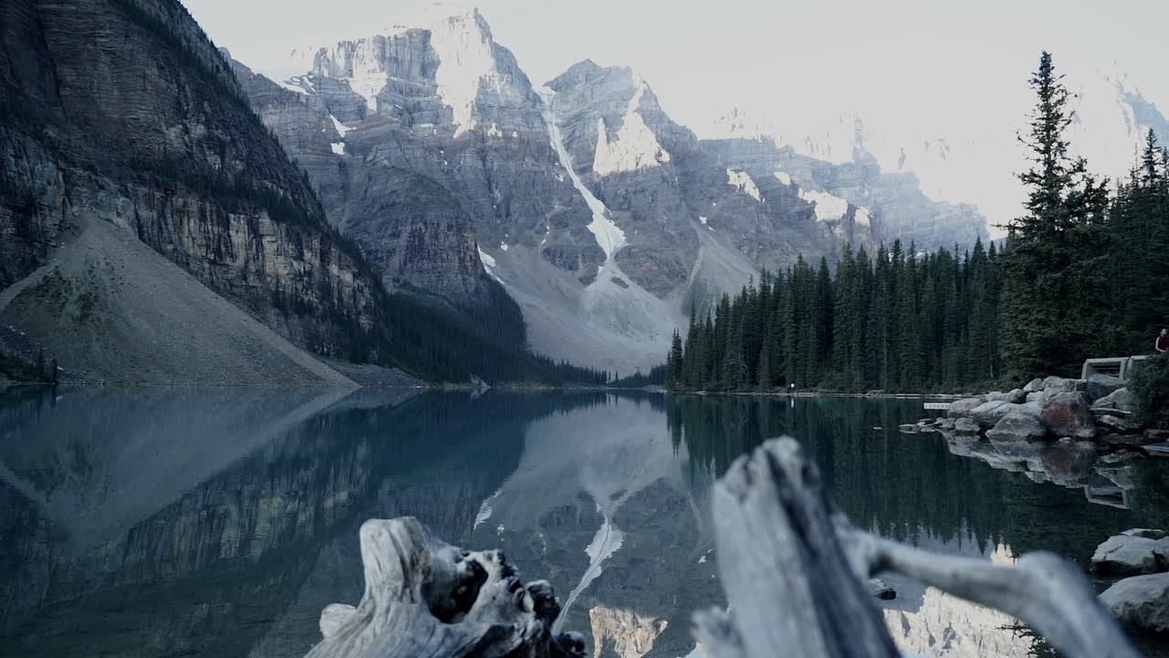 Slow Reveal Of The Stunning Moraine Lake Surrounded By Lush Pine Trees And The Valley Of The Ten Peaks In Banff National Park In Alberta, Canada - Tilt-up Shot