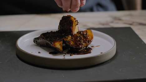 tiro em câmera lenta de um chef servindo um prato de batata doce gourmet em um restaurante
