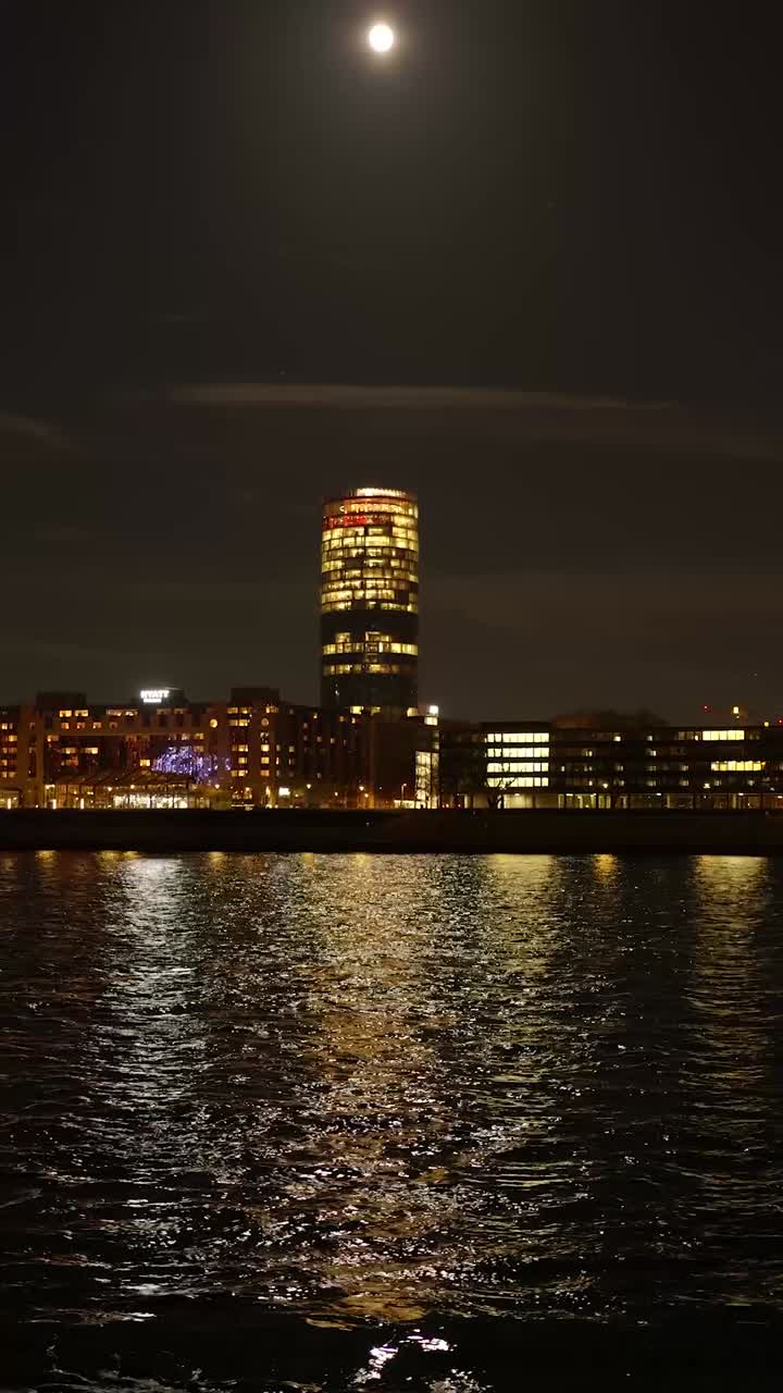Cityscape at Night with Moonlit Water