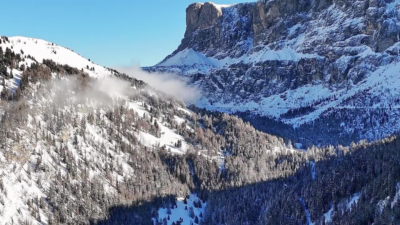 Snow covers mountains in the Alps, Italy with clear blue sky