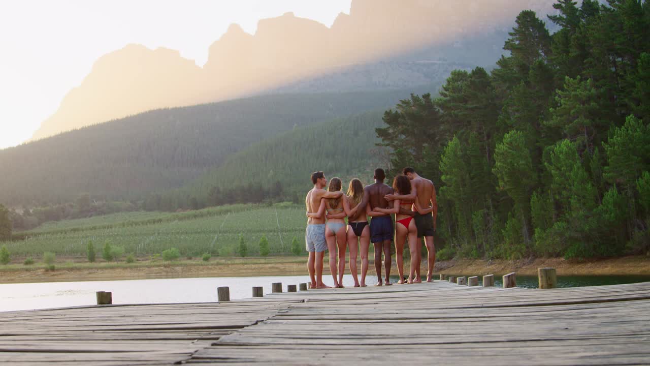 Group of friends admiring view from jetty, back view
