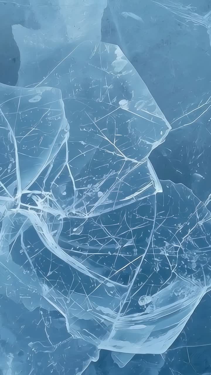 Video verticale: cambio di camera che rivela frammenti di ghiaccio e sottili crepe in uno stagno ghiacciato