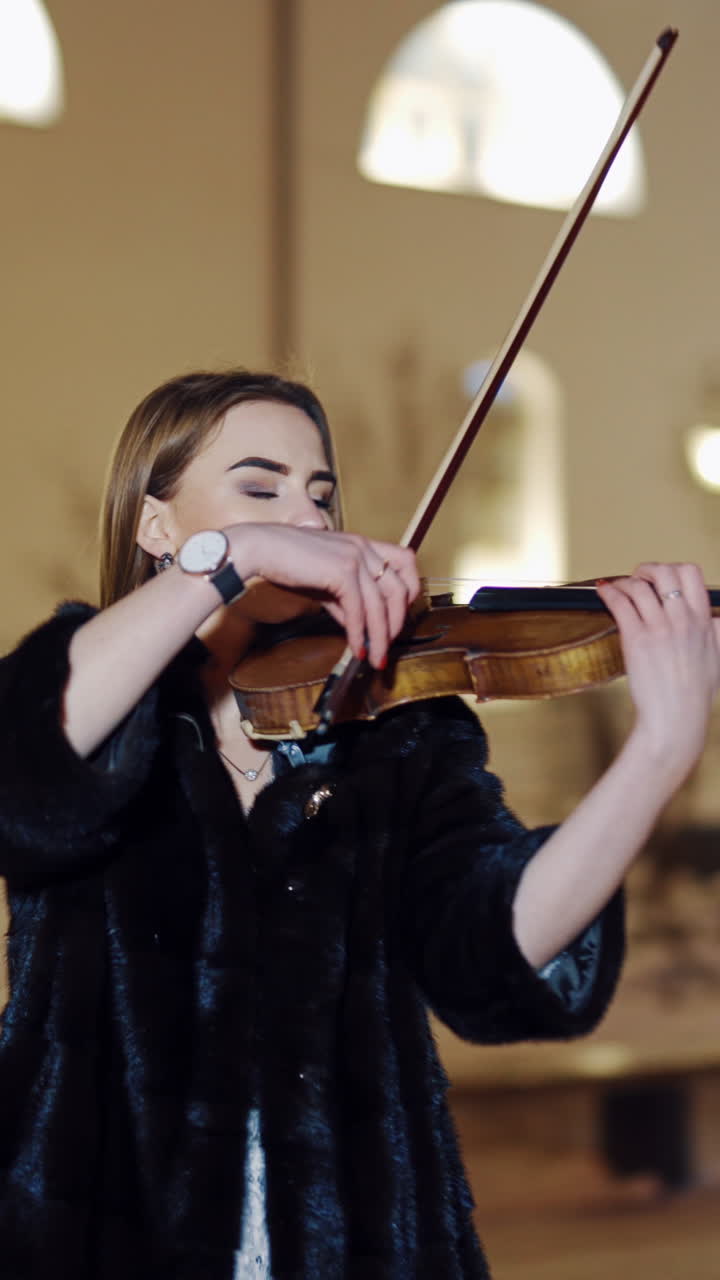 Woman playing on violin at nigh. Luxury girl playing on violin in winter environment. Vertical video
