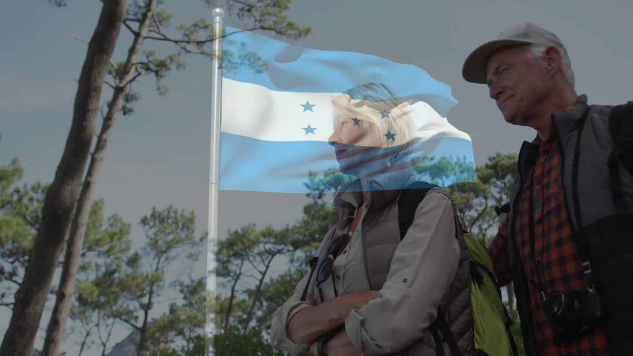 Embracing, elderly couple outdoors with Honduras flag in animation overlay