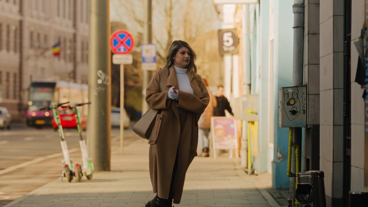 Giovane donna bionda entra in un negozio dal marciapiede, scena urbana, slow motion, luce del mattino, cinematografico