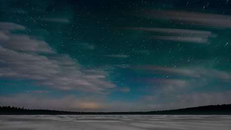 timelapse looking at a turquoise colored night sky above a snow covered lake with clouds and stars moving and weak green colored aurora.
