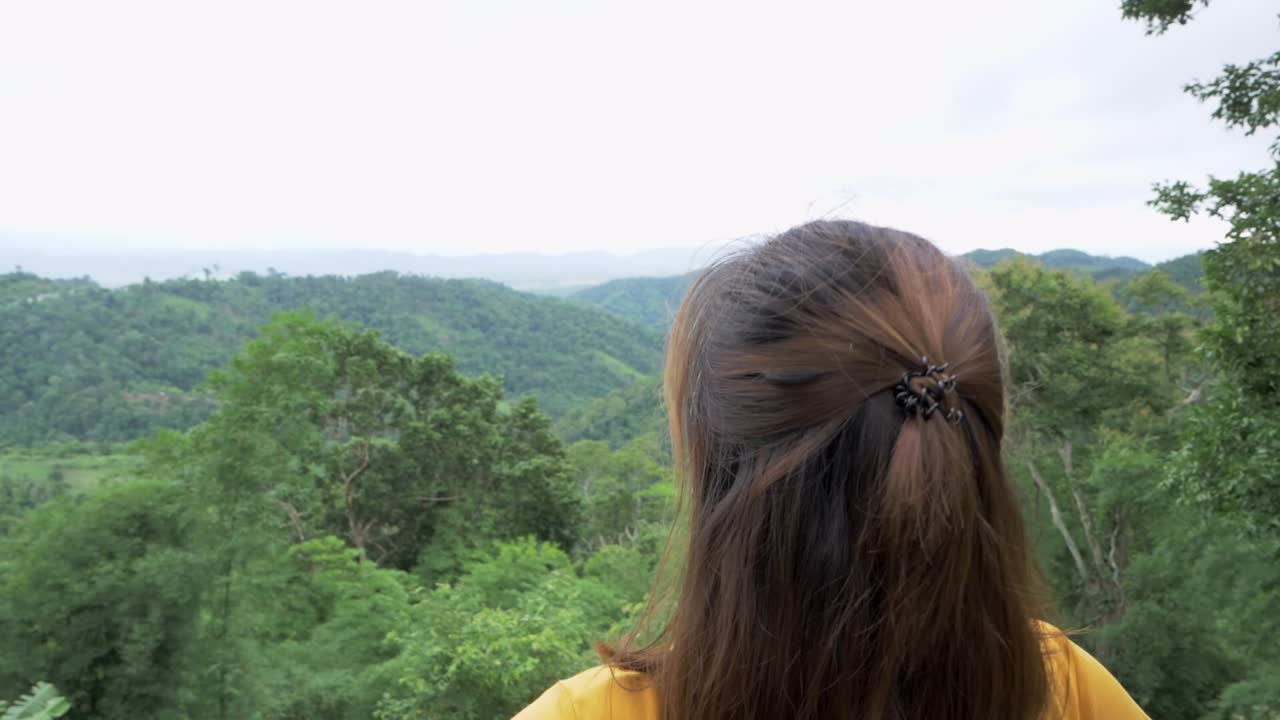 Footage of a woman's head zooms out from her left side to reveal her stands stretched out suggesting her joy of being with nature