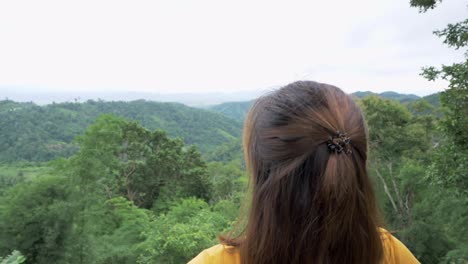 Footage-of-a-woman's-head-zooms-out-from-her-left-side-to-reveal-her-stands-stretched-out-suggesting-her-joy-of-being-with-nature