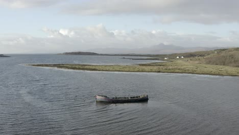 An-aerial-view-of-an-old-shipwreck-on-the-Keillmore-peninsula-on-a-sunny-day-in-Argyll-and-Bute,-Scotland