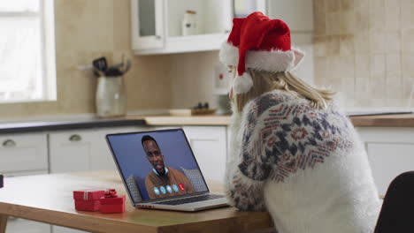 Mujer-Caucásica-Con-Sombrero-De-Papá-Noel-Usando-Una-Computadora-Portátil-En-Un-Video-Chat-Durante-La-Navidad-En-Casa