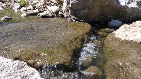 cierre el agua que fluye sobre la roca en un arroyo tranquilo - cámara lenta de 60 fps