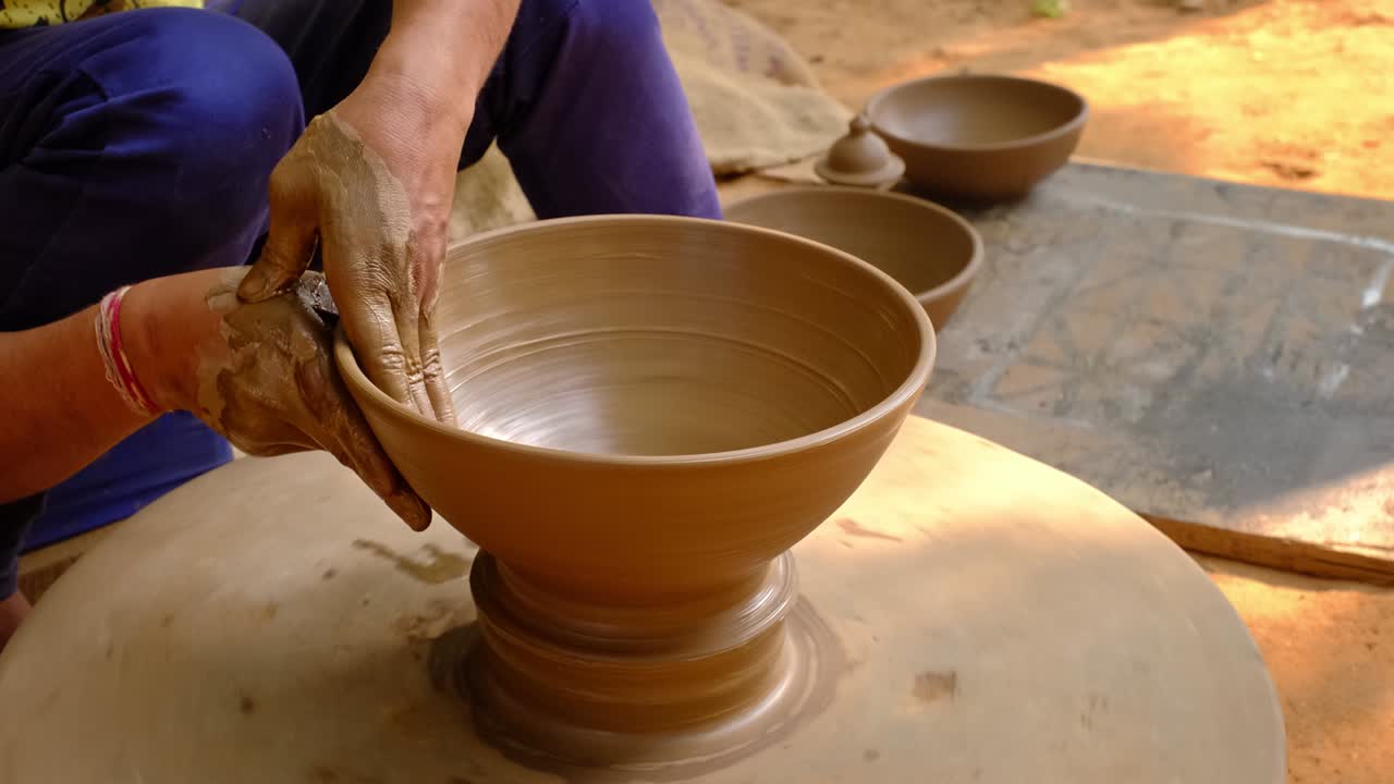 las manos hábiles del alfarero moldeando el barro en la rueda del alfarer y esculpindo jarras de barro. shilpagram, udaipur, rajasthan, india