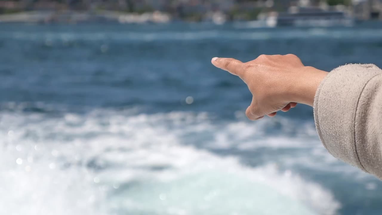 Hand pointing at the sea