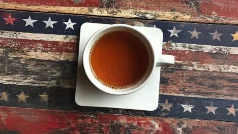 a cup of tea on a wooden table with an american flag pattern