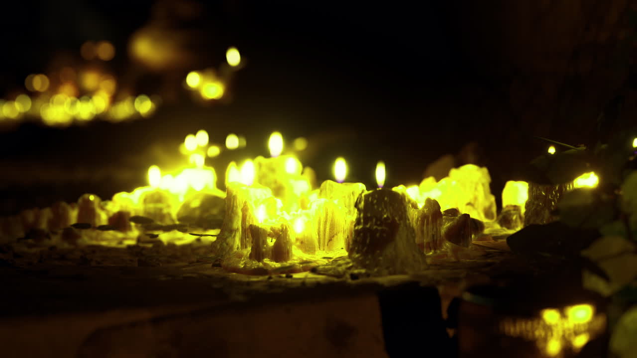 Illuminated pathway created by candles on a dark evening in a serene setting
