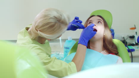 Médico-Que-Trabaja-Con-El-Paciente-En-Una-Clínica-Dental-Moderna.-Mujer-Dentista