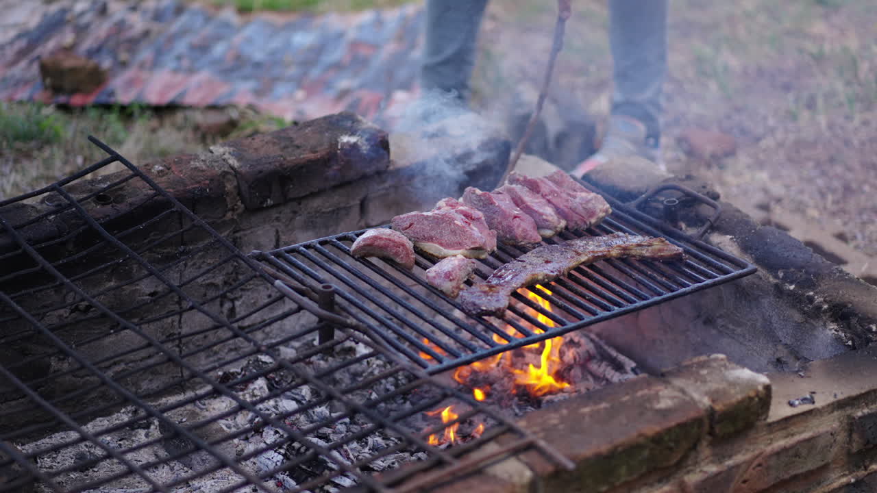 Outdoor grilling scene to making Skirt steak aka Entraña and Top Sirloin Cap aka Picaña over open fire.