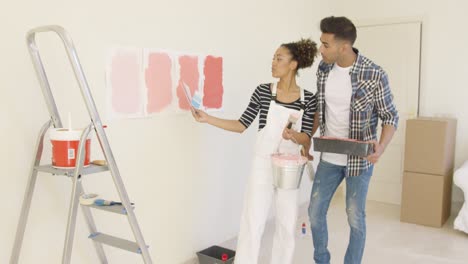 Young-couple-discussing-shades-of-paint-color