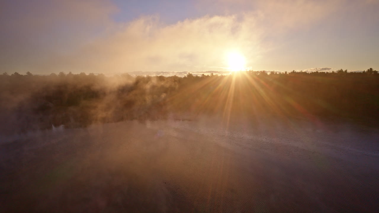 Drone view showing a river flowing through a blanket of autumn trees