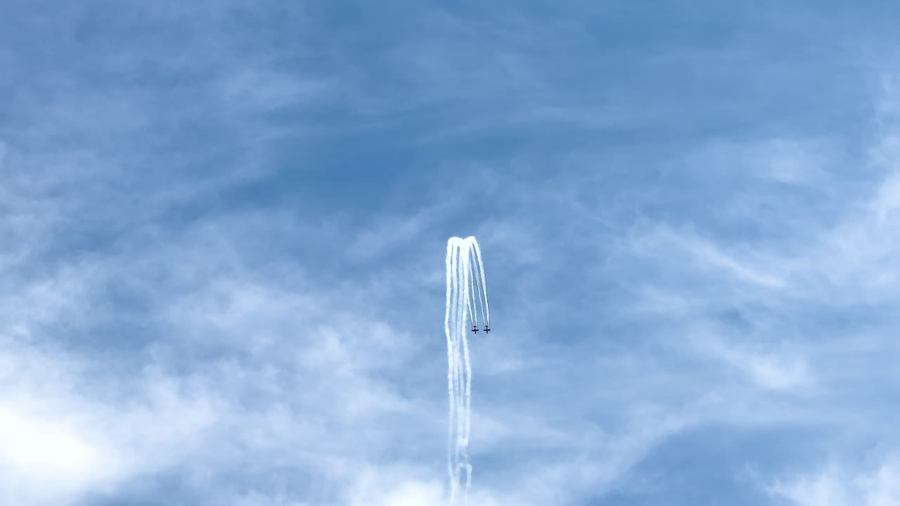 Jet performs aerobatic maneuver, leaving white smoke trails in a clear blue sky. Captured at Avalon Airshow, Geelong, Australia