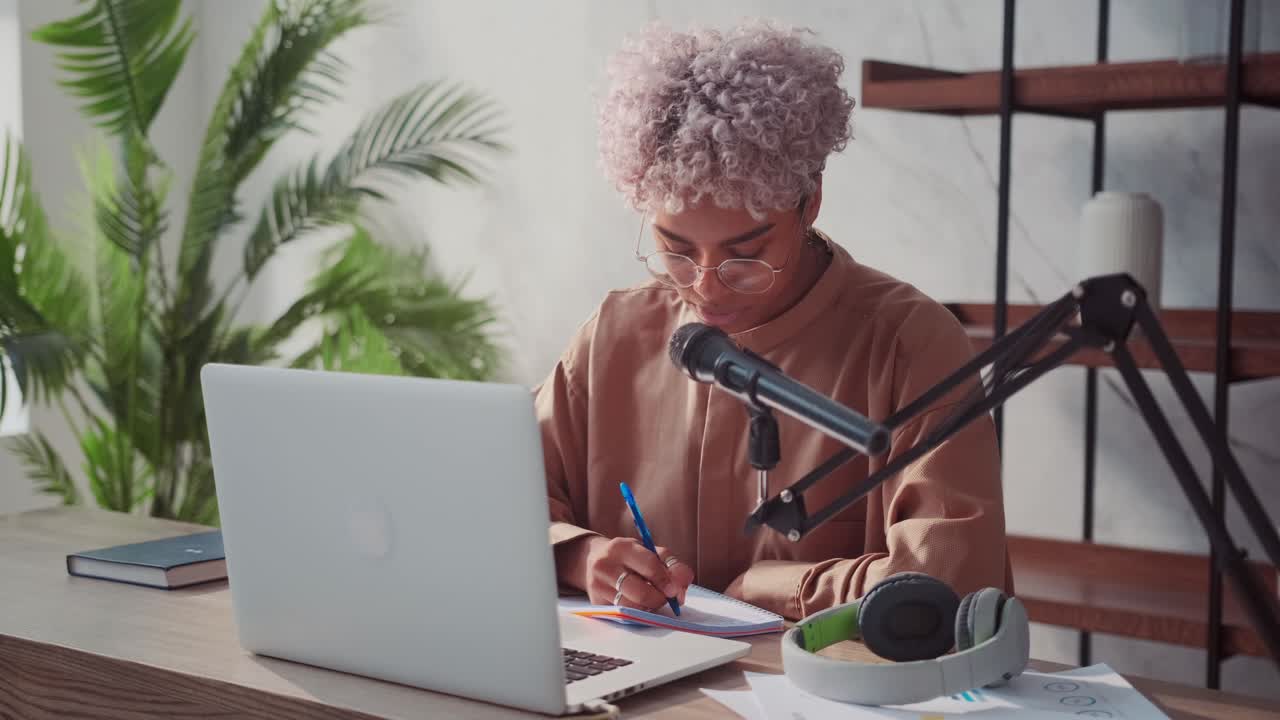 Smiling african blogger leads popular live stream video at home studio podcast