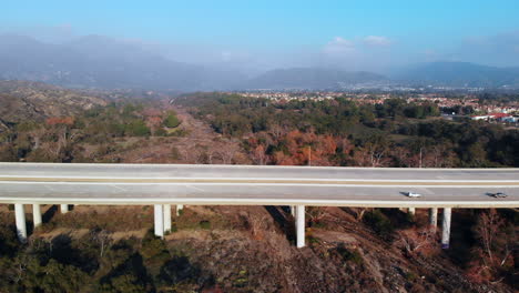 aerial pull back from a bridge with mountain background