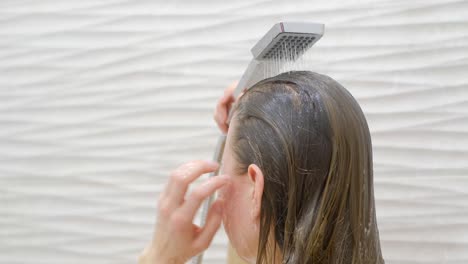 caring for long hair, woman taking a shower in the bathroom. close up