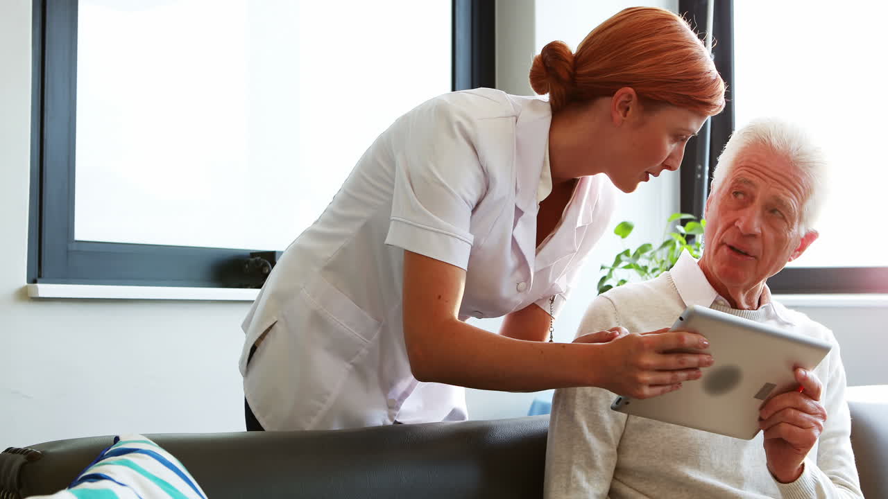 enfermera y paciente de edad avanzada usando una tableta