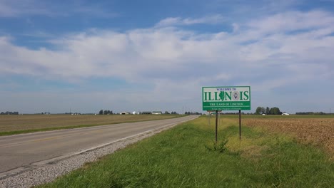 sign along an abandoned rural road through the countryside indicates the illinois state line