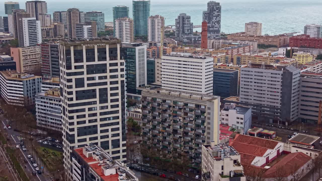 Edifícios residenciais modernos e o litoral no distrito de Poblenou, em Barcelona, Espanha. Filmagem aérea de drone circulando.