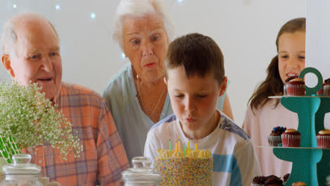 vista frontal de una familia caucásica de varias generaciones celebrando el cumpleaños de su nieto en una cómoda