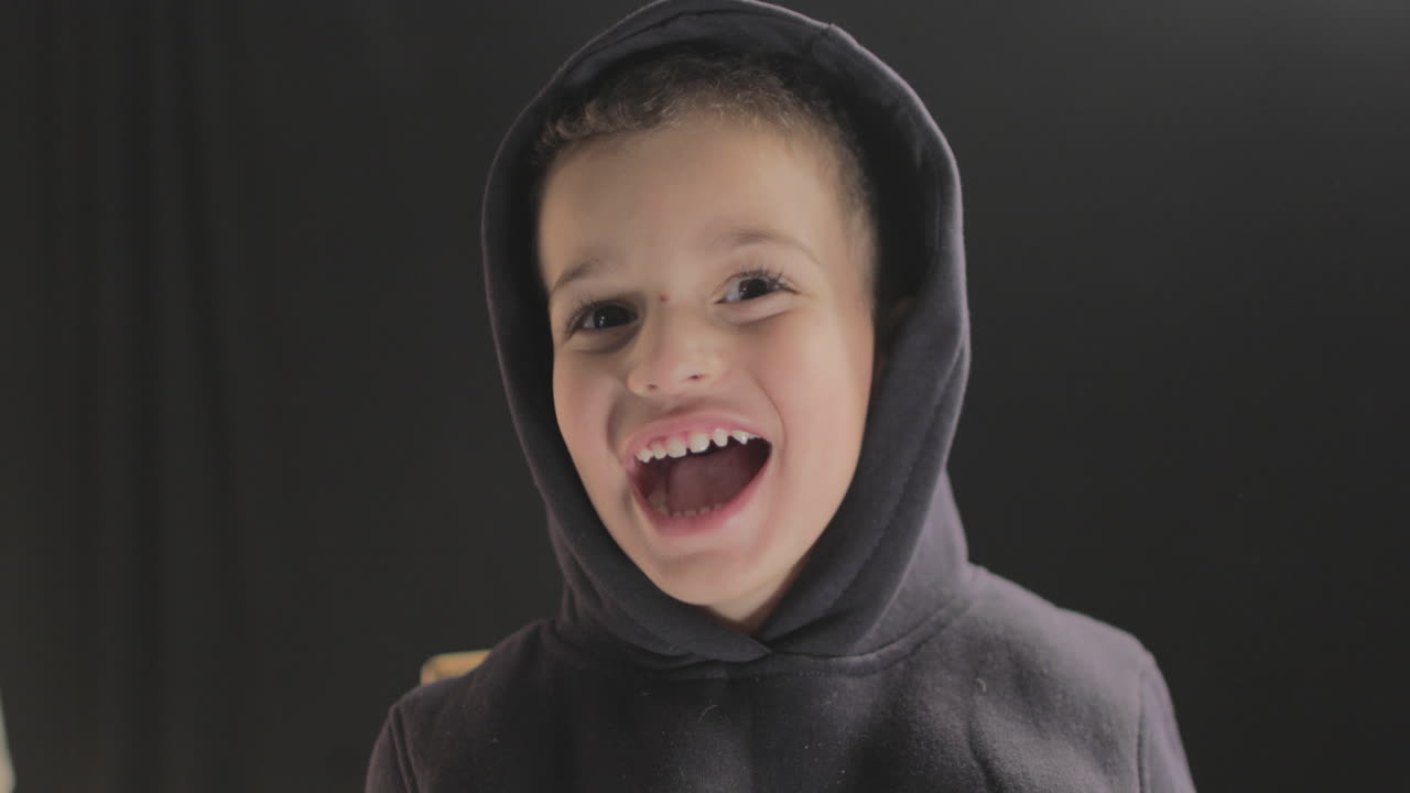 un niño pequeño sonriendo y mostrando diferentes reacciones faciales a la cámara mientras hace un casting de película y una prueba de cámara en 4k