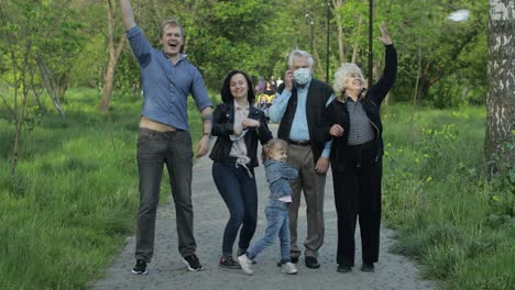 una gran familia en el parque se quita las máscaras médicas después del final de la cuarentena contra el coronavirus