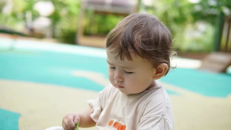 beautiful caucasian toddler playing outdoor during daytime. closeup