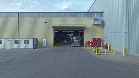 aerial pullback from semi truck in large loading dock inside of steel warehouse